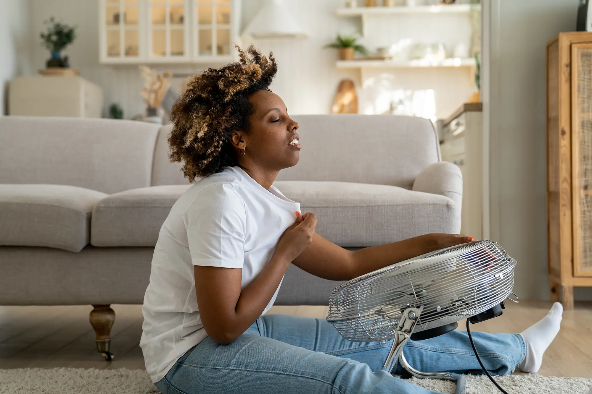 overheated-woman-sitting-on-floor-in-living-room-u-2025-03-08-14-49-10-utc_scaled AC not keeping up