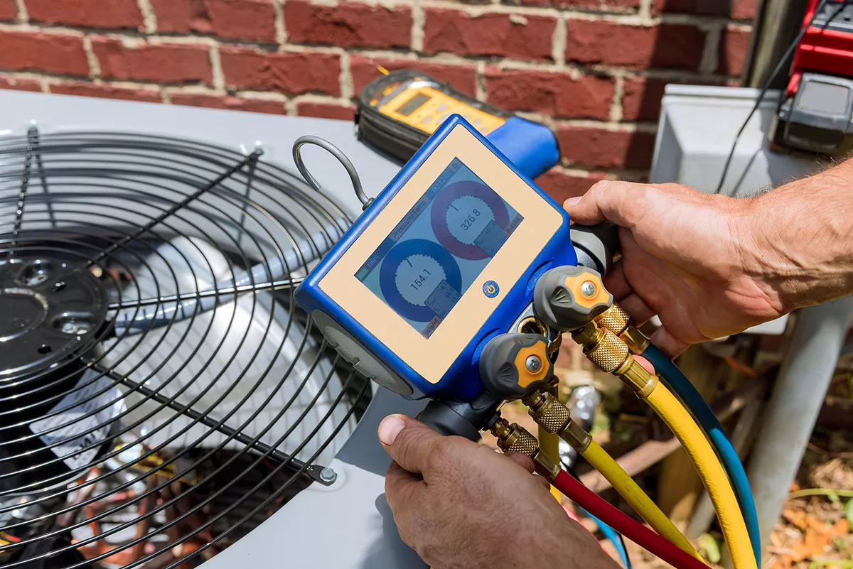 AC technician checks a home's outdoor AC unit.